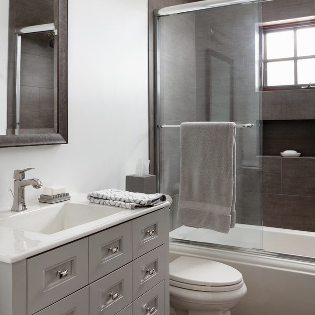 calm guest bath in neutrals, with vanity in custom color to match shower tile surround
